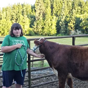 Tony with his steer in front of a fence.